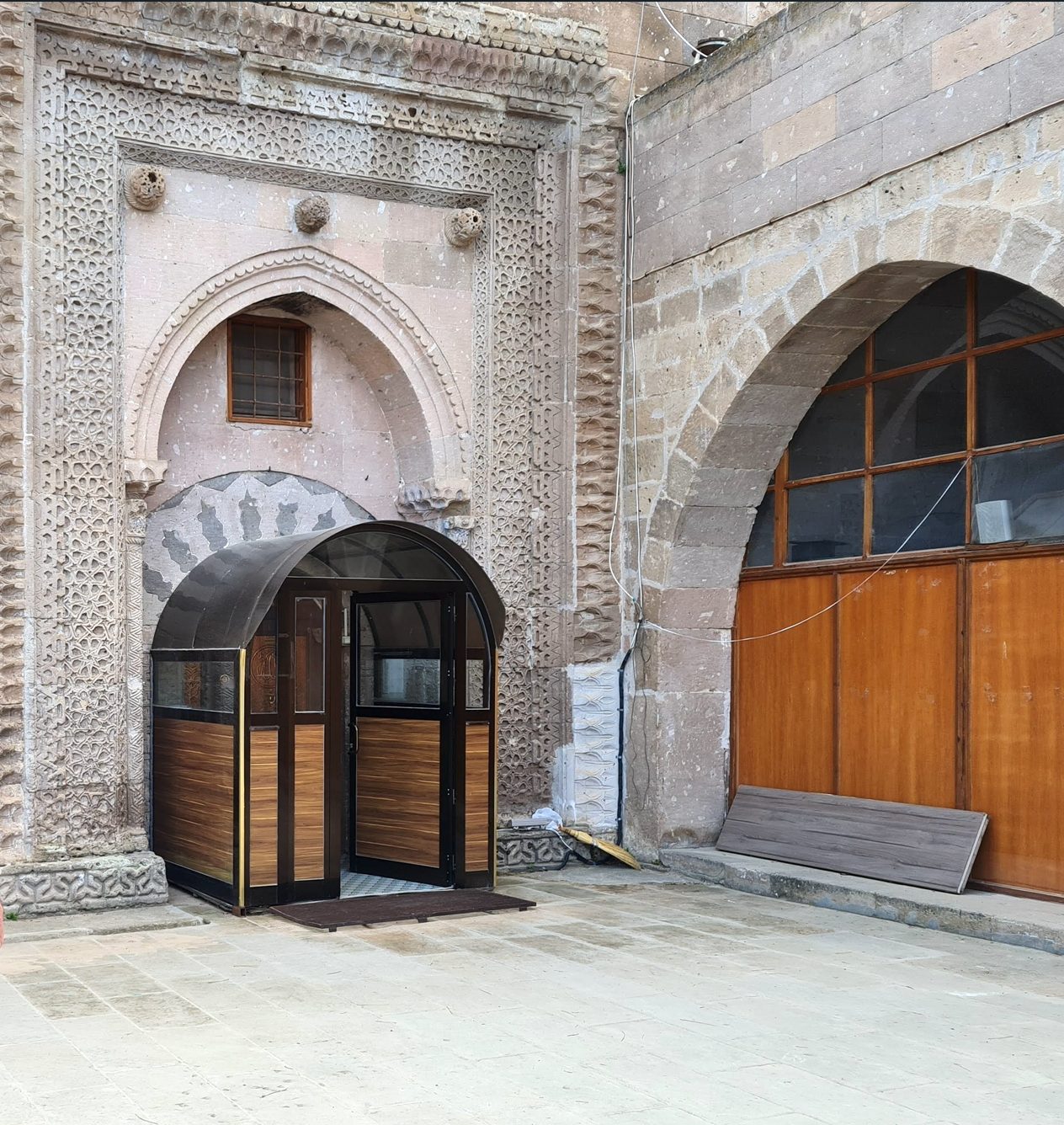 Kuzey cephedeki bezemeli taçkapı ve sağda yazlık mescidin kemeri.